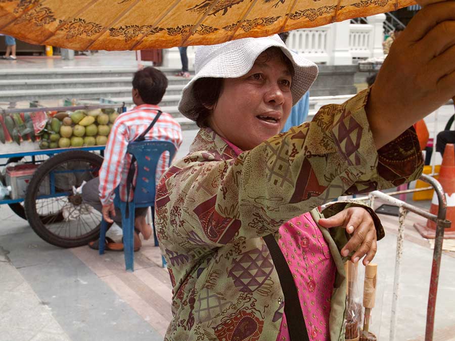 Woman Selling Sun Parasols at Wat Traimit, Bangkok, Thailand